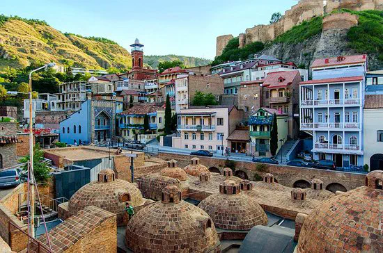 The brick domes of Abanotubani's historic sulfur baths beneath Narikala Fortress.