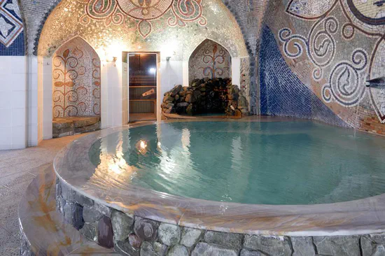 A tiled sulfur-bath room in Abanotubani with a circular warm-water pool and sauna.