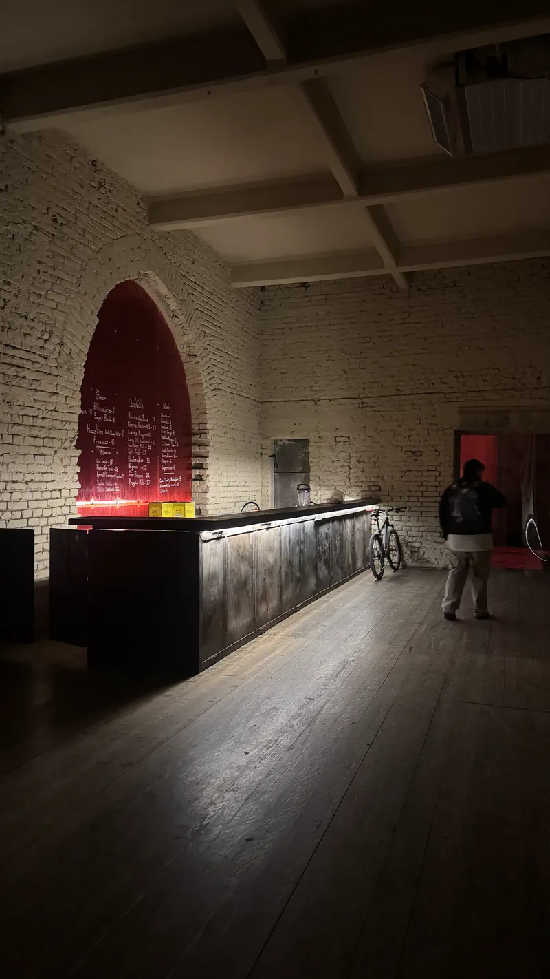The Mutant Radio bar inside a white brick room, framed by a tall red arch.